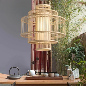 Lustre rotin bambou rétro présenté suspendu au dessus d'une table à thé